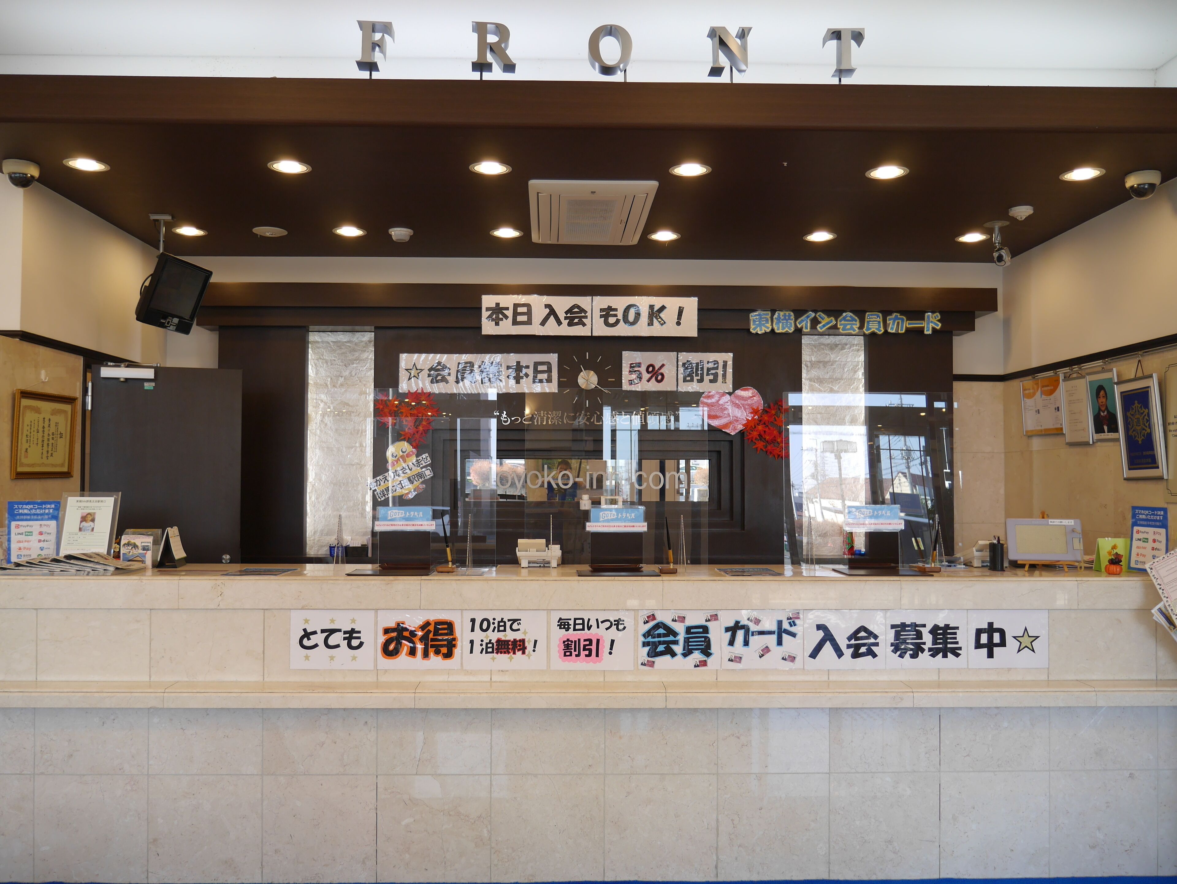 A reception area with a sign reading "FRONT" and various promotional signs.