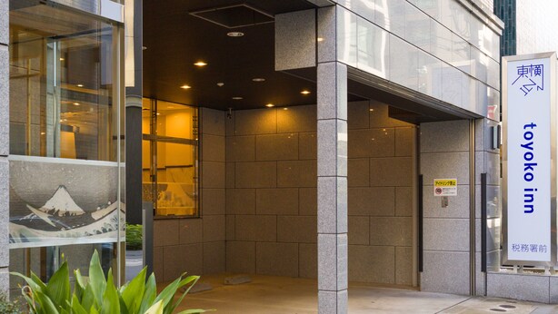 L'entrada d'un edifici amb un rètol que diu "Toyoko Inn".