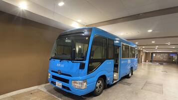 Un autobús azul estacionado en un amplio estacionamiento interior con piso de baldosas y techo alto.