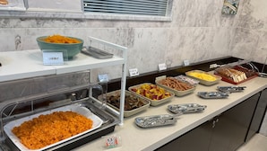 Un buffet proposant une variété de plats et d’ustensiles de service.