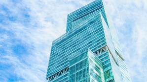 Een hoog, modern gebouw van glas met een rasterachtige gevel.