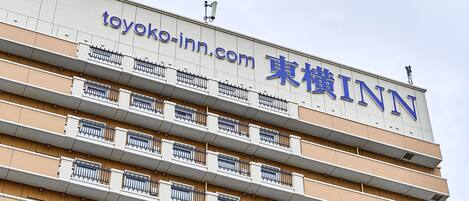 Un edificio de varios pisos con balcones y un letrero que dice 'toyoko-inn.com'.