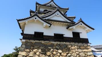 Un château japonais traditionnel, doté de plusieurs niveaux et d’une base en pierre.