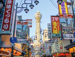 A bustling urban street with a prominent tower in the background. - Toyoko Inn Osaka Tsutenkaku Mae (Osaka)