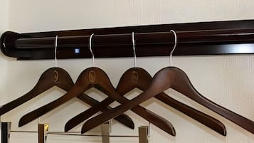 A wall-mounted wooden coat rack with four hangers.