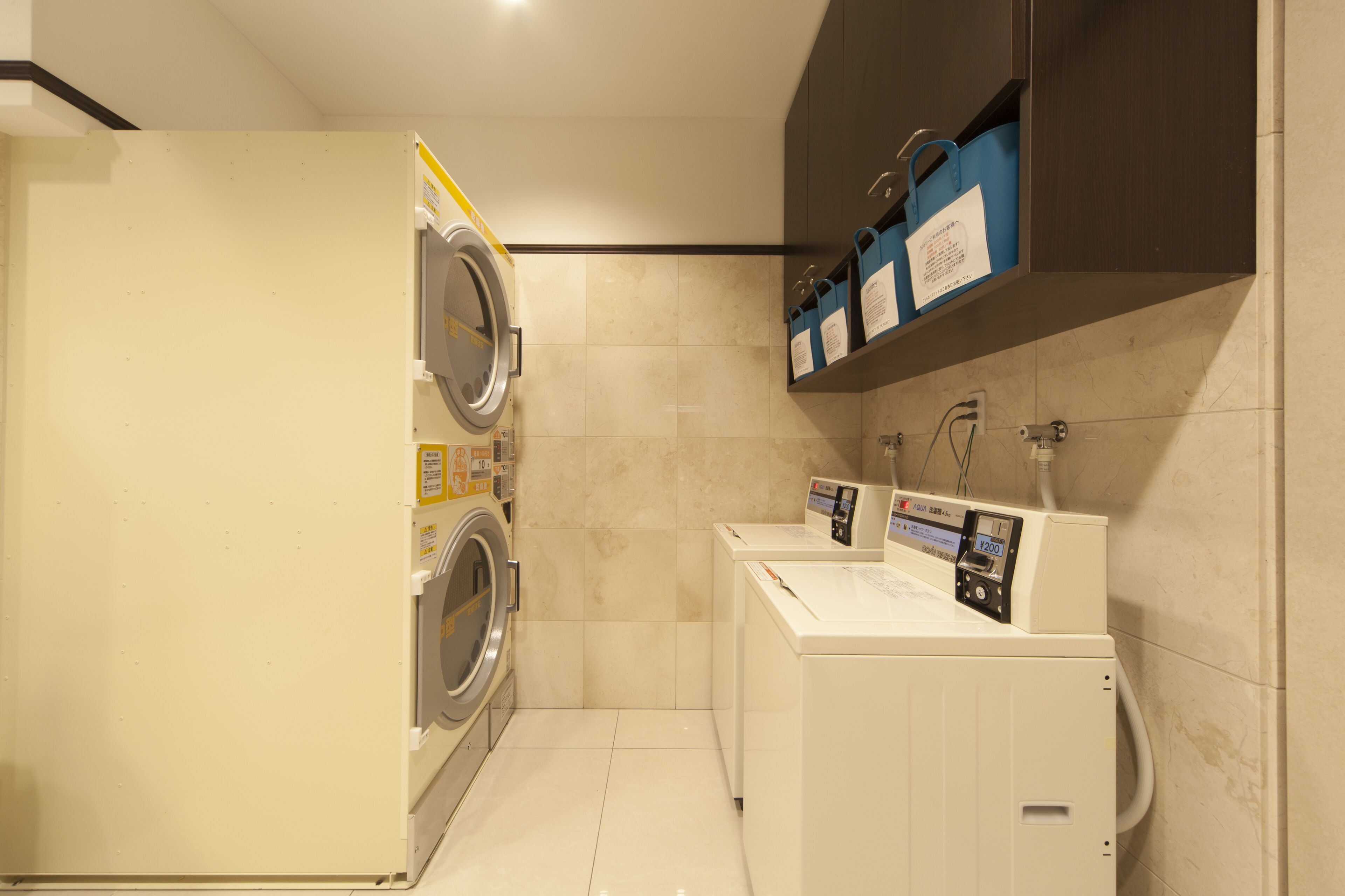 A compact laundry room with a washing machine, dryer, and a small sink area.