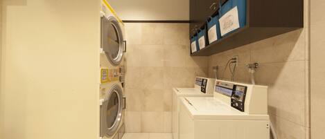 A compact laundry room with a washing machine, dryer, and a small sink area.