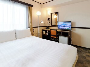 A hotel room with a large bed, a desk with a computer, a desk lamp, and a mirror. - Toyoko Inn Osaka Namba Nippombashi (Osaka)