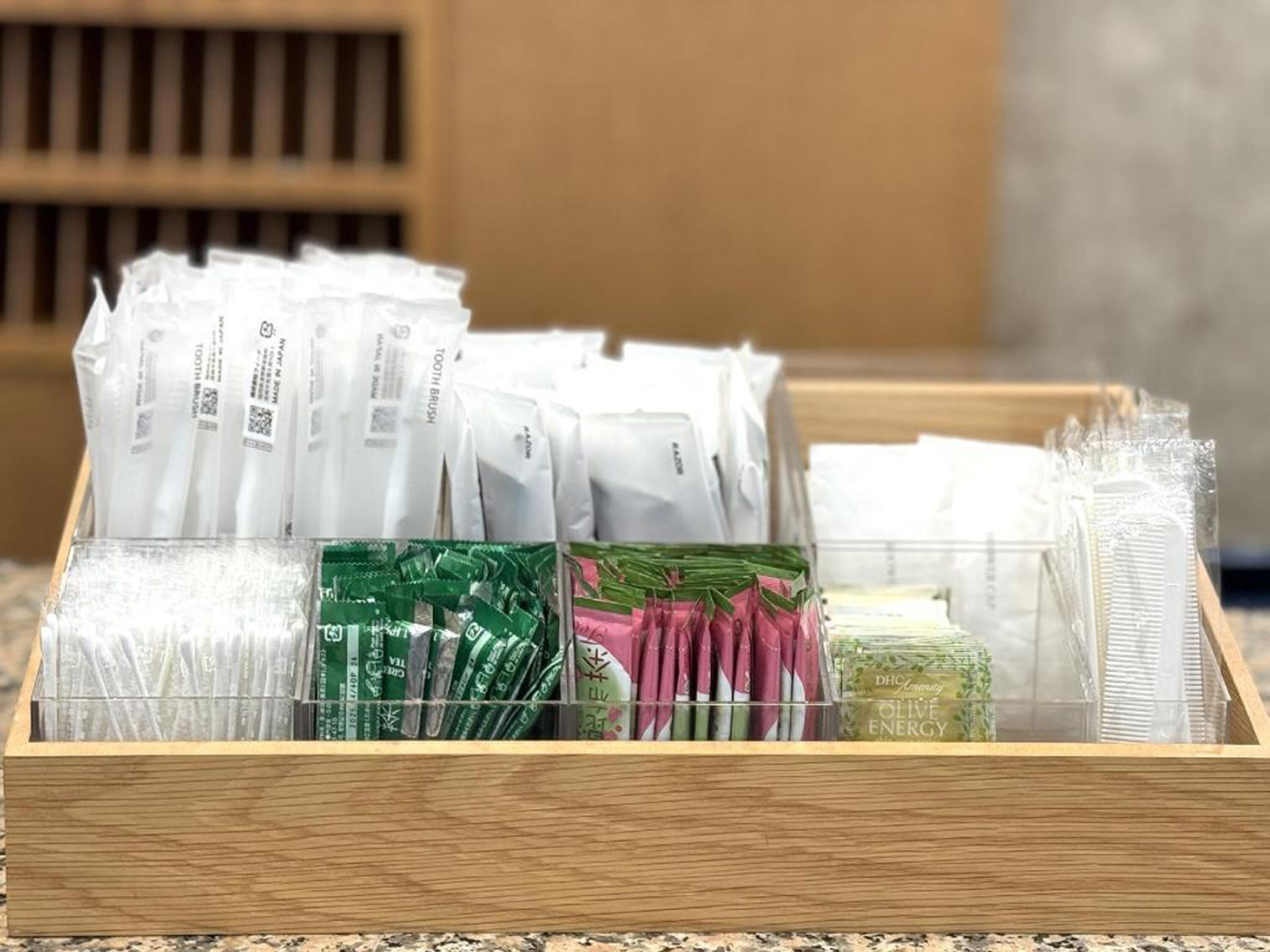 A wooden storage box containing various packaged items, likely for sale or storage.