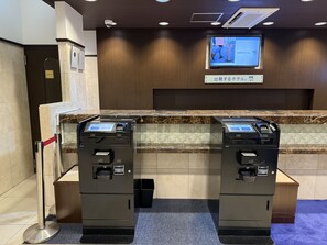 A reception area with two self-service kiosks, a private room sign, and a television screen displaying information. - Toyoko Inn Osaka Namba Nippombashi (Osaka)