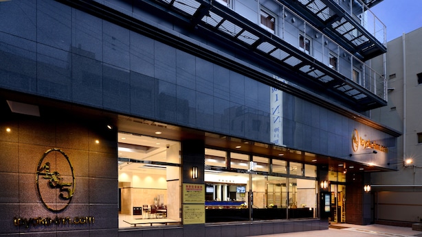 A hotel entrance with a modern facade, large windows, and a visible reception area. - Toyoko Inn JR Kobe Station Kita (Kobe)