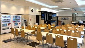 A spacious cafeteria with multiple tables and chairs, vending machines, and a visible entrance labeled "FRONT". - Toyoko Inn JR Kobe Station Kita (Kobe)