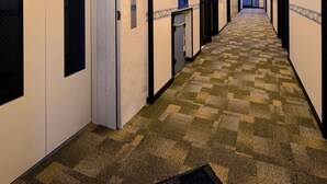 A hotel hallway with carpeted floors, doors, and a vending machine. - Toyoko Inn JR Kobe Station Kita (Kobe)