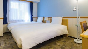A hotel room with a large bed, a bedside table, a lamp, and a window with curtains. - Toyoko Inn JR Kobe Station Kita (Kobe)