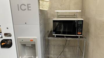Un angolo cottura compatto con erogatore di ghiaccio, forno a microonde e un piccolo lavandino.