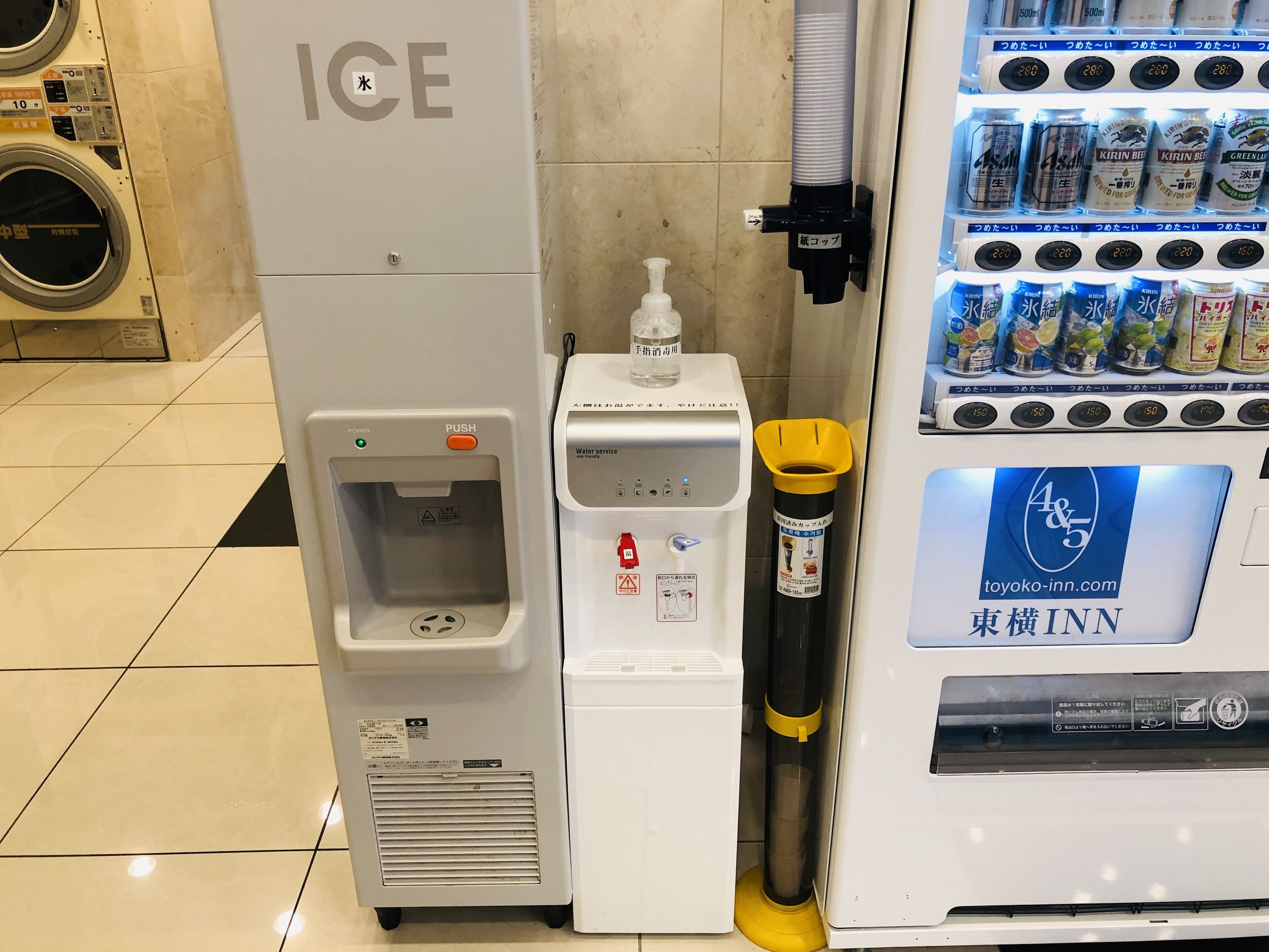 A water dispenser and a beverage vending machine in a hotel setting.