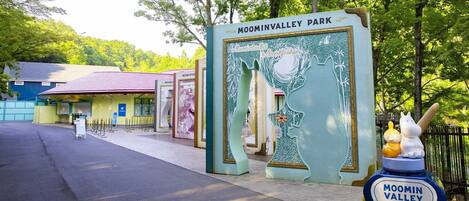 The entrance to MooMinValleyPark with a distinctive sign and a large decorative tree cutout.