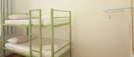 A bunk bed with white bedding and a wooden floor.