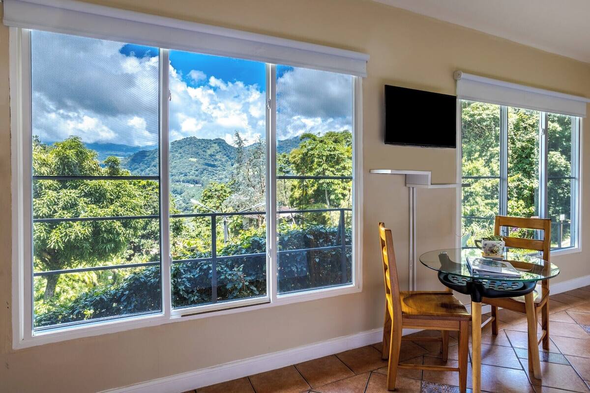 A room with large windows offering a view of a mountainous landscape.