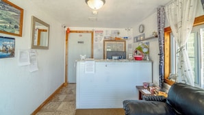 A compact living space with a kitchenette, a dining area, and a seating area. - Green Acre Motel by OYO Near Rush County Airport (La Crosse)