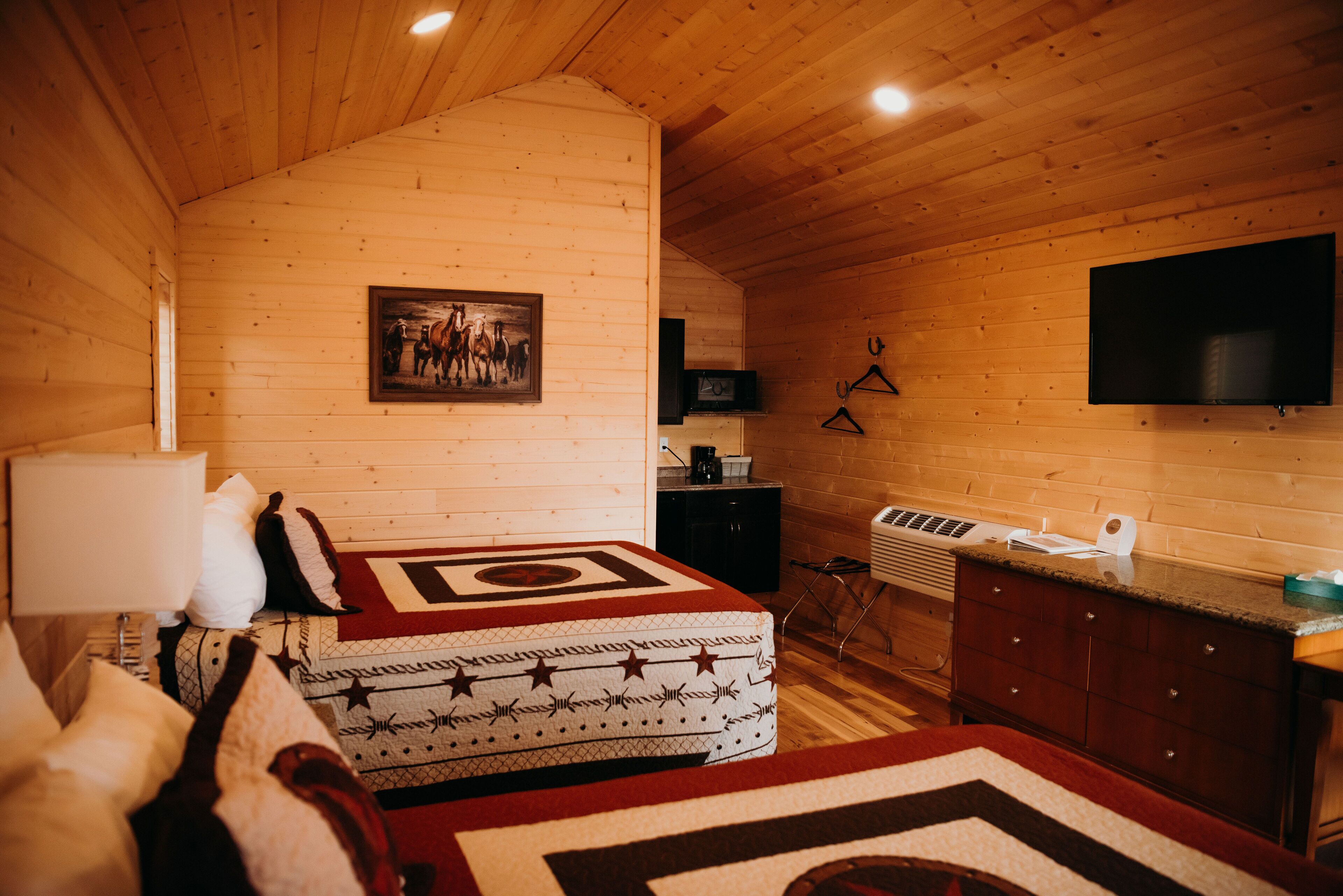 Ein gemütliches Cabin-Zimmer mit Bett, Schreibtisch und Fernseher.