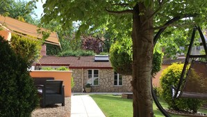 A stone house with a red-tiled roof, a paved pathway, and a well-maintained lawn. - Résidence Chez Gino (Etaples)