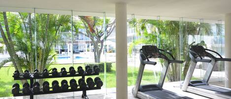 A gym with treadmills and a rack of dumbbells.