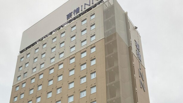 A tall building with multiple windows and a sign that reads "INN".