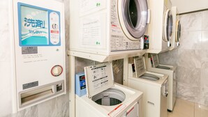 A laundry facility with multiple washing machines and a self-service dryer. Instructions and safety guidelines are displayed on the machines. - Toyoko Inn Kagoshima Chuo Station Higashi (Kagoshima)