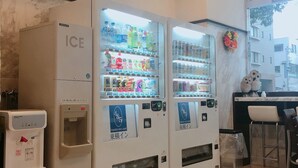A vending machine area with multiple beverage dispensers, a water dispenser, and a trash bin. - Toyoko Inn Kagoshima Chuo Station Higashi (Kagoshima)