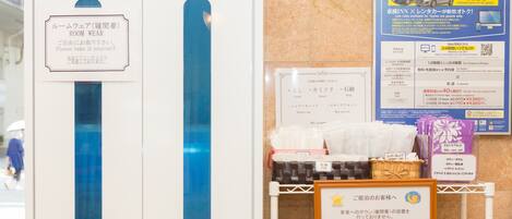 A hotel reception area with a sign indicating room wear items available for guests to take.