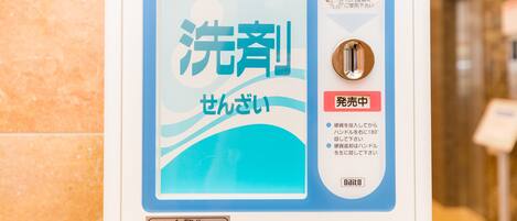 A public restroom with a blue and white sign indicating a 30 yen fee for toilet use. Instructions for using the toilet are provided in Japanese.