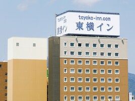 A multi-story building with a signboard advertising 'toyoko-inn.com' and '東横イン' in Japanese.