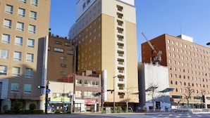 Un edificio de varios pisos con un letrero destacado de 'Toyoko Inn' y otro letrero que dice 'Kawasaki Life'.