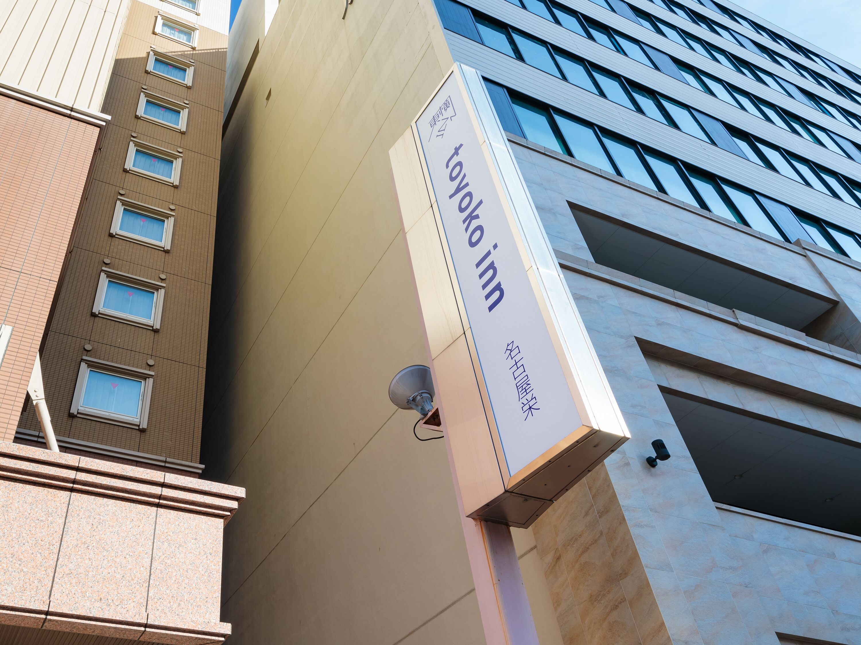 Un edificio con un letrero que dice "Toyoko Inn" y una antena parabólica.
