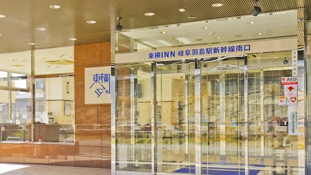 A hotel entrance with a glass door, a sign with Japanese characters, and a tiled floor. - Toyoko Inn Gifu Hashima Station Shinkansen Minami (Hashima)