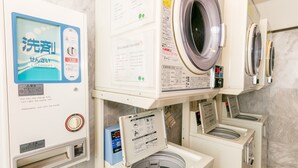 A laundry area with a washing machine, dryer, and a control panel with instructions. - Toyoko Inn Gifu Hashima Station Shinkansen Minami (Hashima)