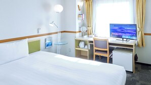 A hotel room with a bed, desk, chair, computer, and window with curtains. - Toyoko Inn Shonan Hiratsuka Station Kita 2 (Hiratsuka)