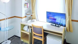 A hotel room with a desk, chair, computer, and a small refrigerator. - Toyoko Inn Shonan Hiratsuka Station Kita 2 (Hiratsuka)