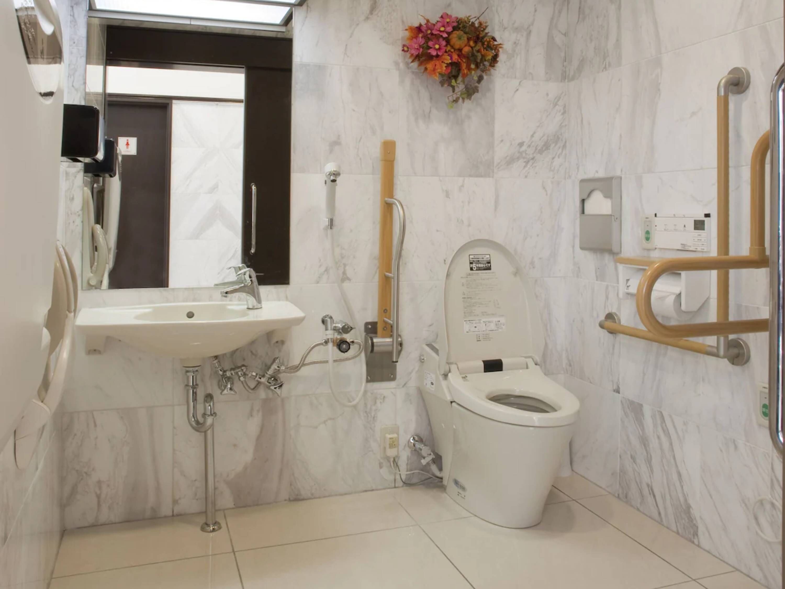 A modern bathroom with a white sink, a toilet, and a shower area.