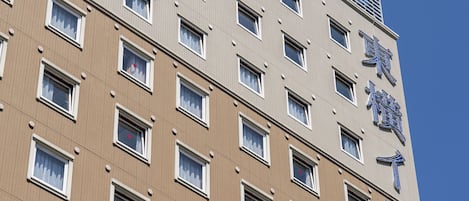 Ein mehrstöckiges Gebäude mit vielen Fenstern und einem sichtbaren Schild mit chinesischen Schriftzeichen.