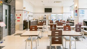 A spacious cafeteria with multiple tables and chairs, vending machines, and a kitchen area. - Toyoko Inn Okinawa Ishigaki jima (Ishigaki)