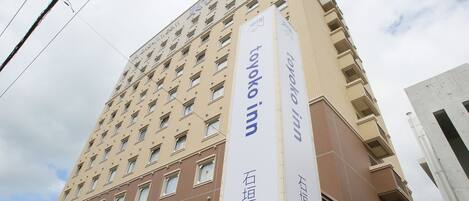Un edificio de hotel alto con numerosas ventanas y un letrero llamativo que dice 'Toyoko Inn'.