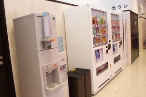 A vending machine with a water dispenser and a beverage vending machine in a hotel corridor.