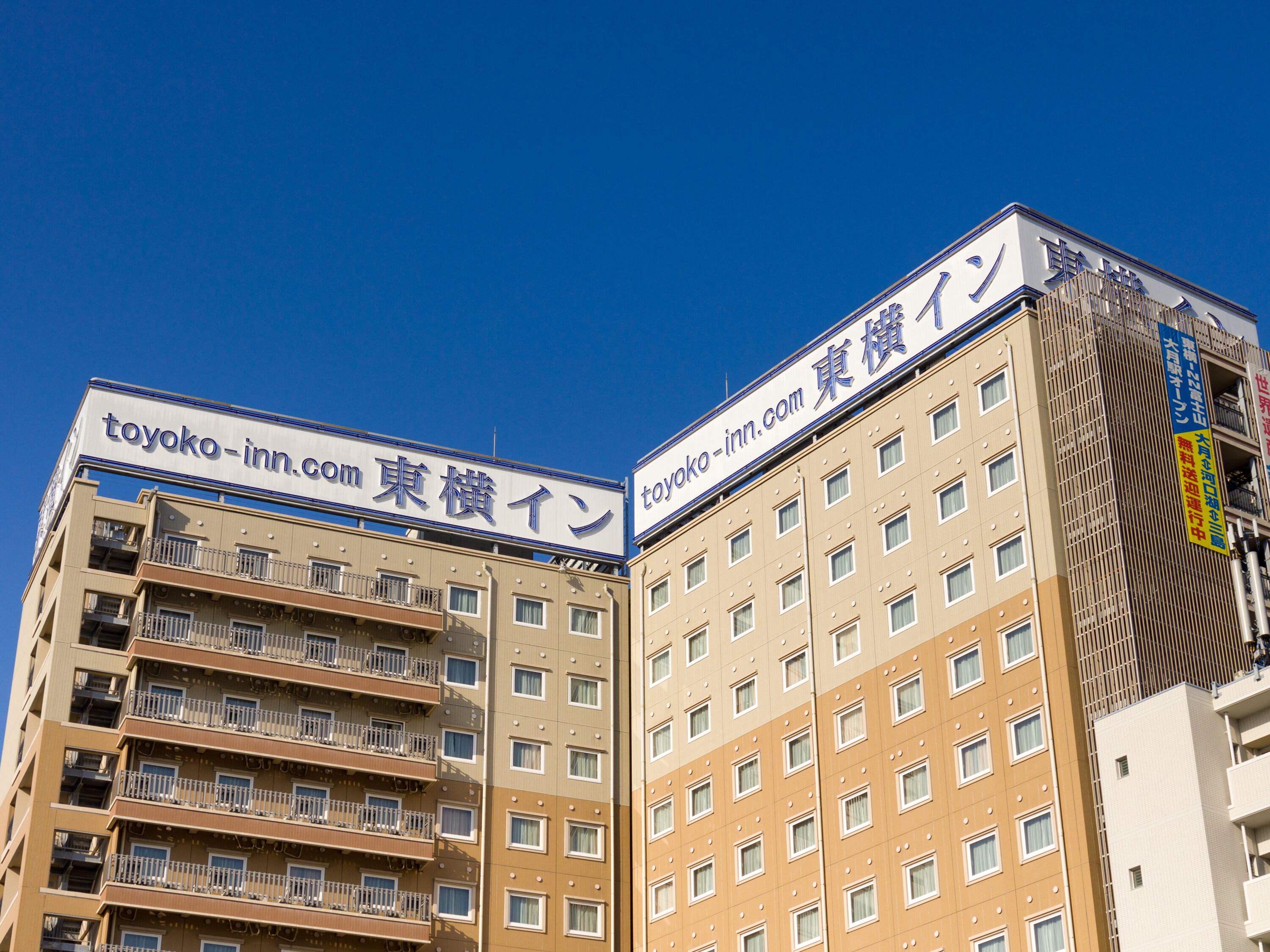 A multi-story hotel with signage in both English and Japanese.