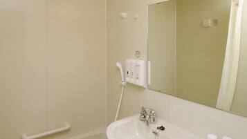 Een bad/douchecombinatie, een haardroger, pantoffels