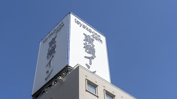 A building with a large billboard advertising a hotel. - Toyoko Inn Fukuoka Tenjin (Fukuoka)