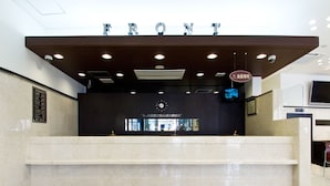 A reception desk with a sign reading "FRONT" and a digital screen displaying information. - Toyoko Inn Fukuoka Tenjin (Fukuoka)