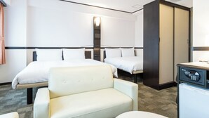 A hotel room with two beds, a sofa, a desk with a computer, and a wardrobe.