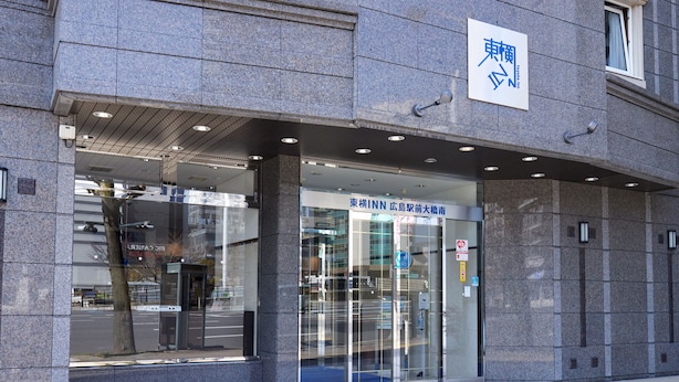 Un bâtiment doté d’une façade en pierre et d’une entrée en verre.